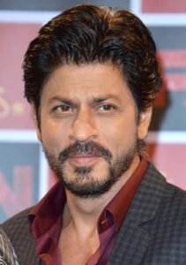 Shah Rukh Khan in a casual outfit, smiling during a public event